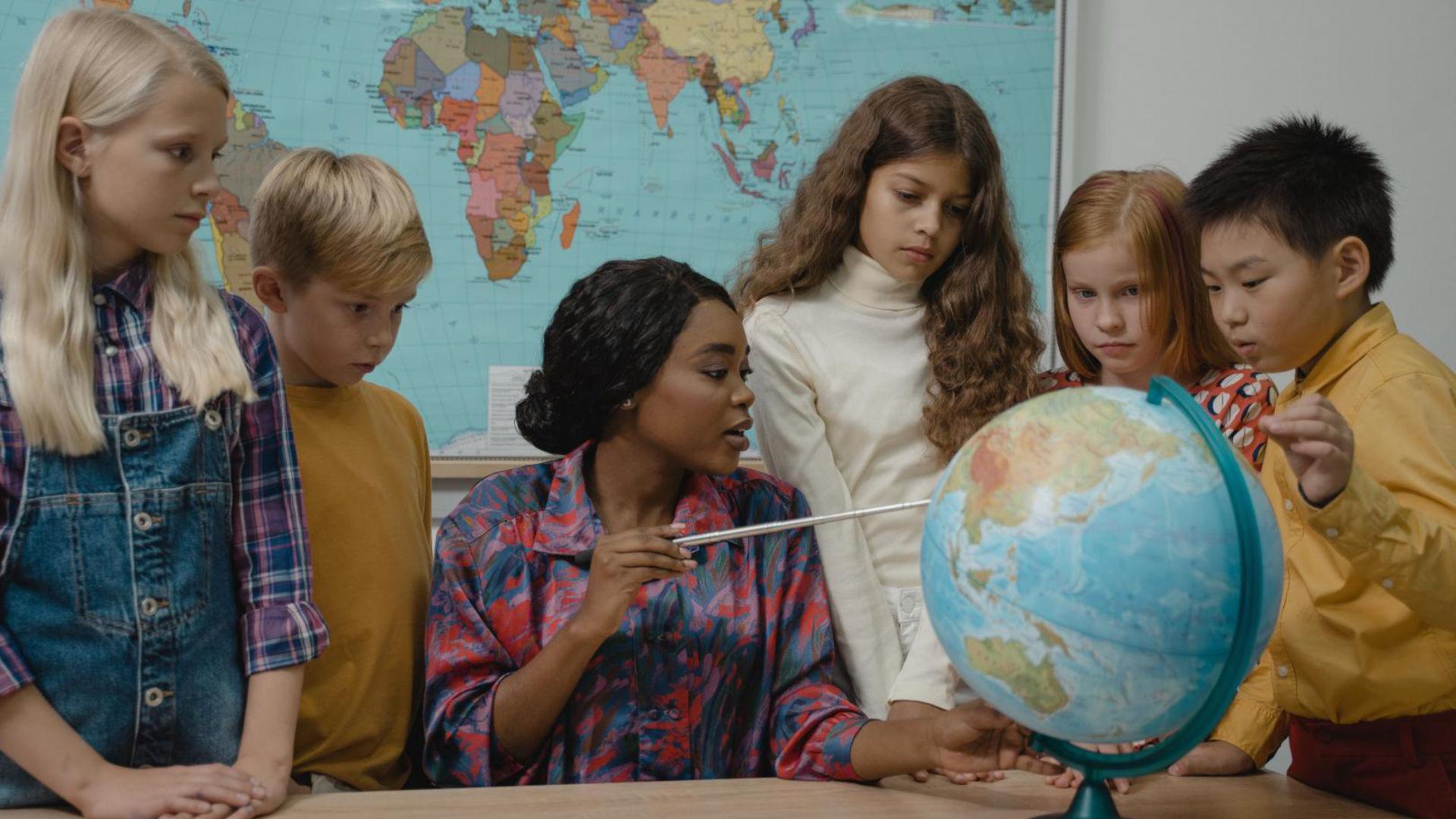 Fotografia de uma turma aprendendo sobre o globo terrestre