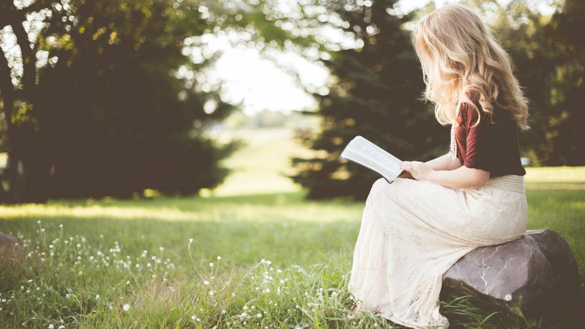 Mulher lendo um livro num parque